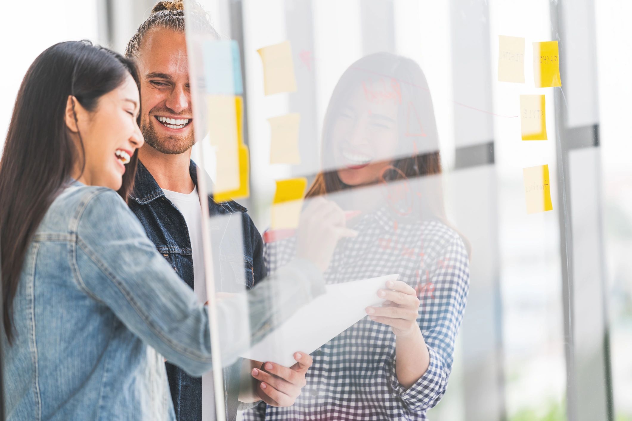 Team planning growth strategy on a glass board